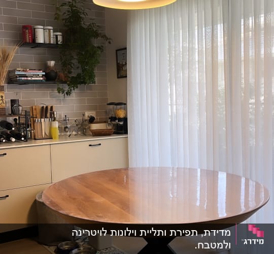 וילון לבן שקוף ליד שולחן עגול מעץ